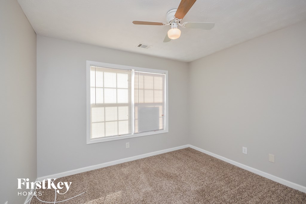a bedroom with a ceiling fan and a window