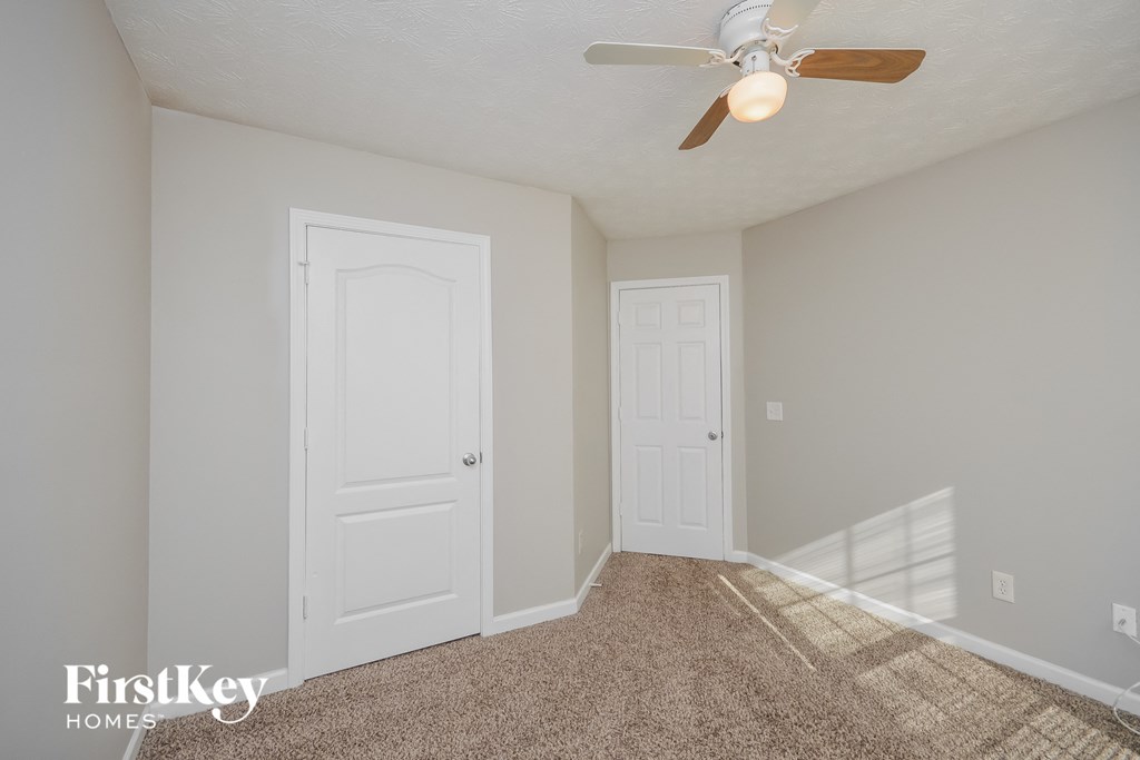 a bedroom with a ceiling fan and a closet