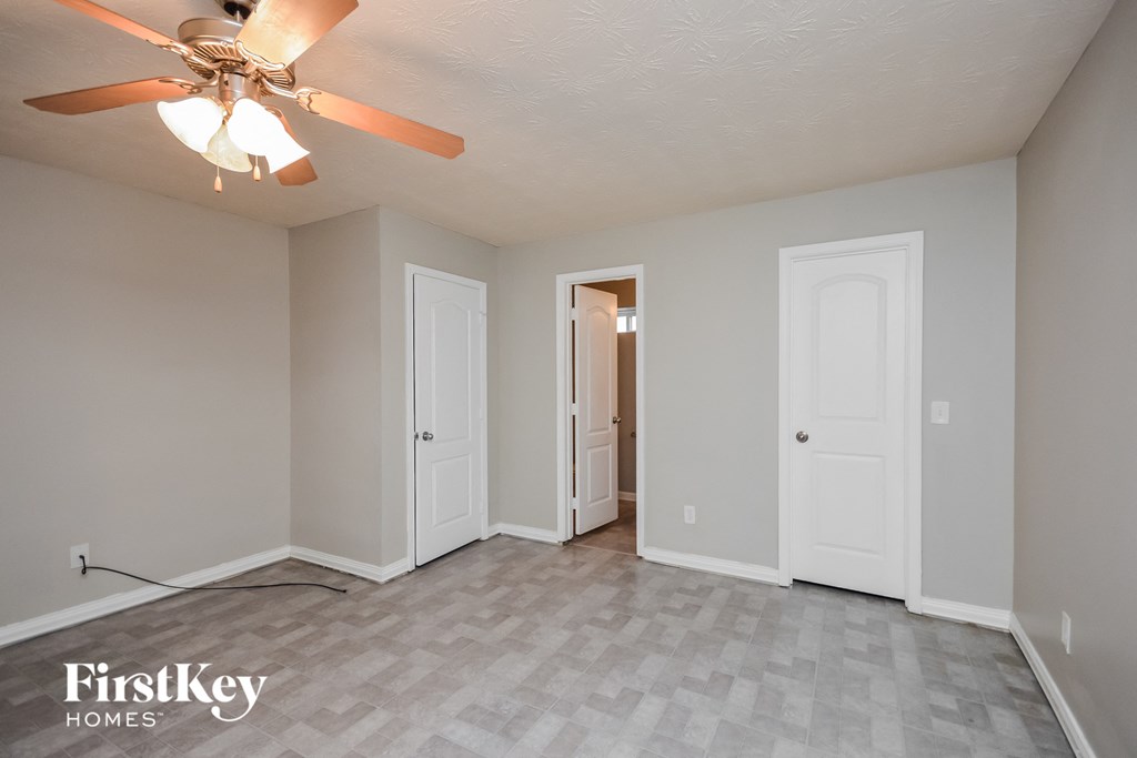 the living room of an empty house with a ceiling fan
