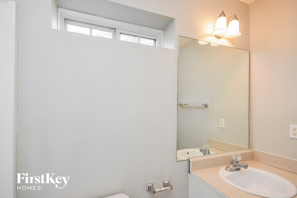 a bathroom with a mirror and a sink and a toilet