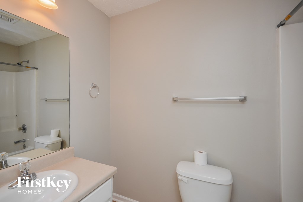 a bathroom with a toilet and a sink and a mirror