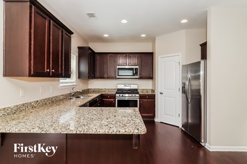 A kitchen with brown cabinets and a granite countertop.