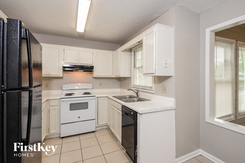 A kitchen with white appliances and cabinets.