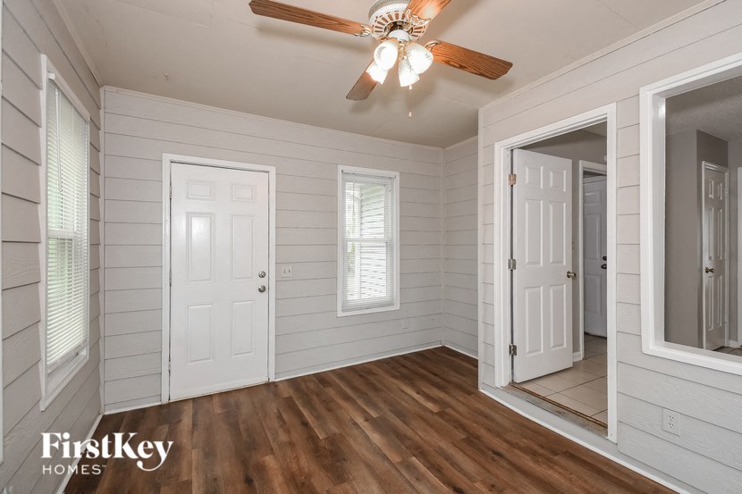 A room with a ceiling fan and wooden floors.