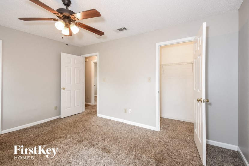 A room with a ceiling fan and two doors.