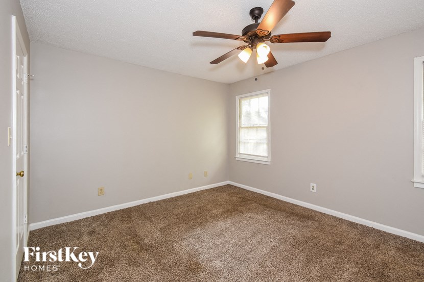 A room with a ceiling fan and a window.