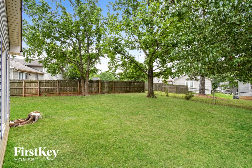 A backyard with a fence and trees.