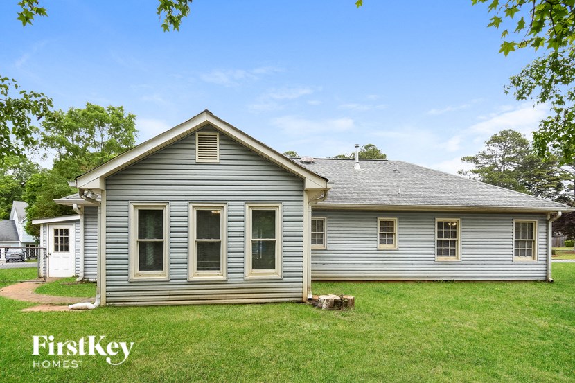 A house with a grey siding and a white door is shown.