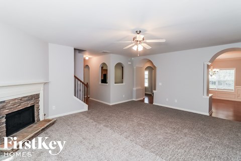 a living room with a fireplace and a ceiling fan