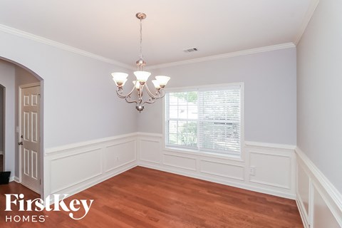 a dining room with a window and a chandelier