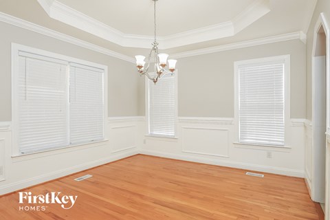 a dining room with a wood floor and a chandelier