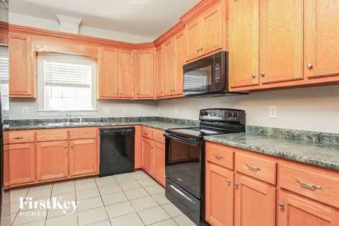 a kitchen with wooden cabinets and black appliances