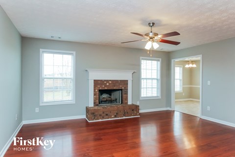 a living room with a fireplace and a ceiling fan