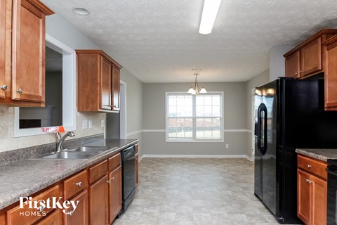 a kitchen with wooden cabinets and a black refrigerator