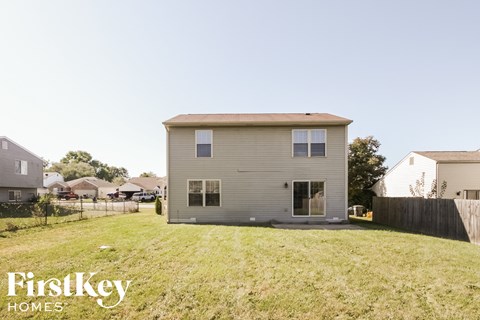 the back of a house in a backyard with a grassy yard