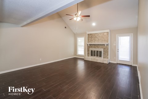 the living room with wood flooring and a fireplace