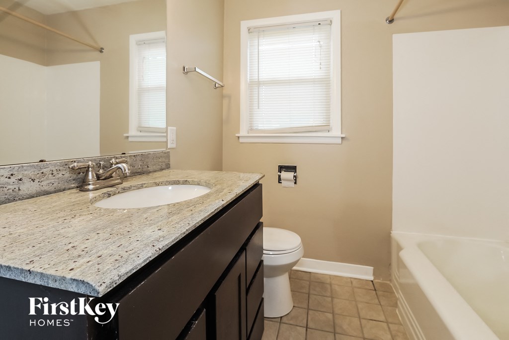 an image of a bathroom with a sink toilet and bath tub