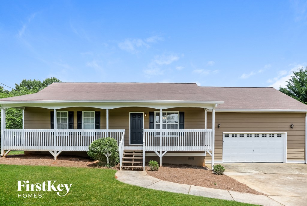 a beige house with a porch and a white garage door