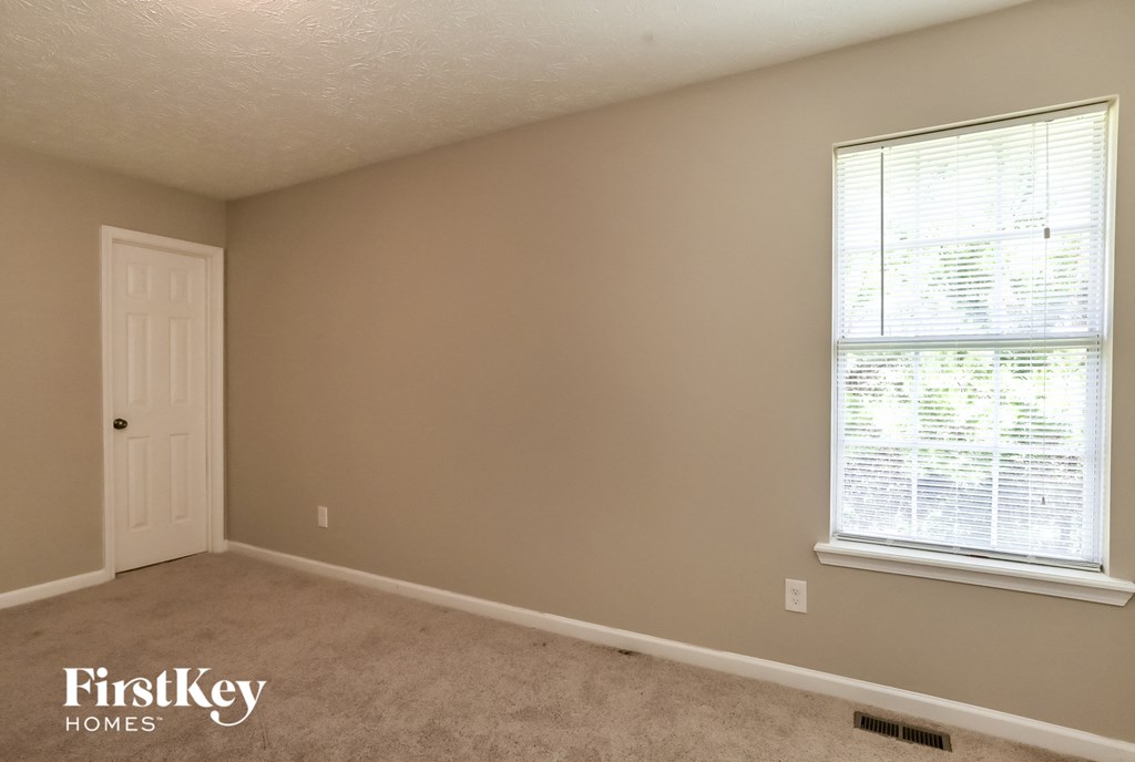 a bedroom with a window and a white door
