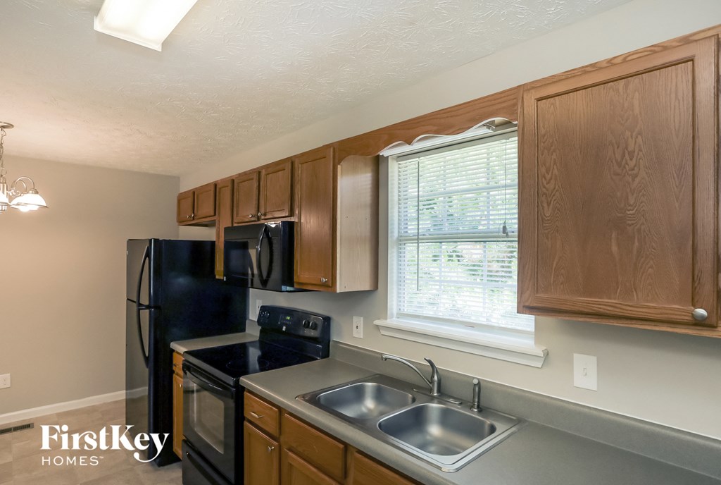 a kitchen with black appliances and wooden cabinets