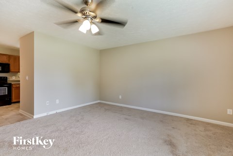 a living room with carpet and a ceiling fan