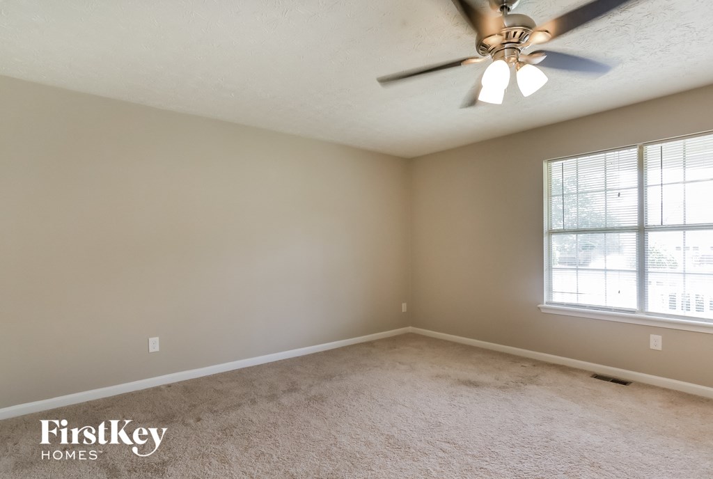 a living room with a ceiling fan and a window