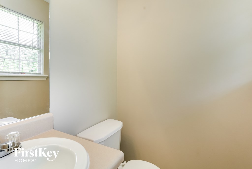 a bathroom with a toilet and a sink and a window