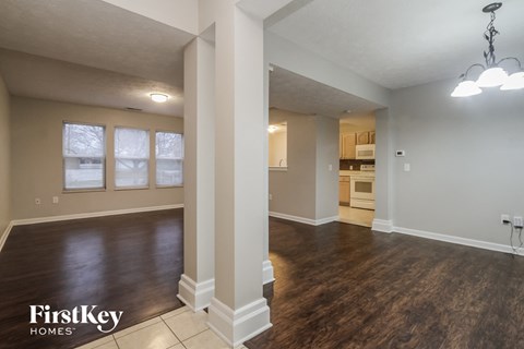 the living room and dining room of an empty house