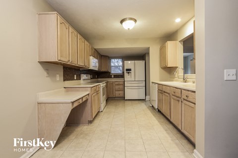 a large kitchen with wooden cabinets and white appliances
