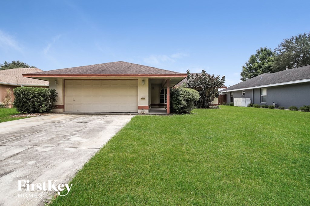 A house with a brown roof and a garage door is for sale.