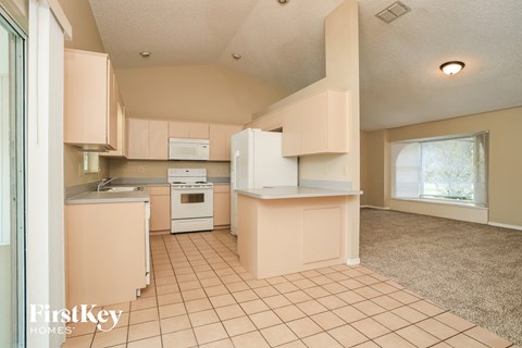 A kitchen with a white stove top oven and a white refrigerator.