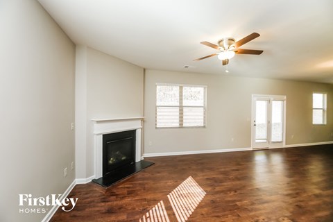 a living room with a fireplace and a ceiling fan