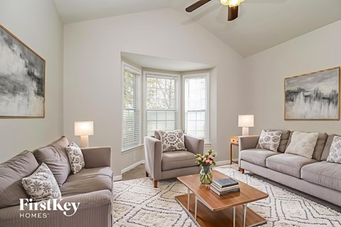 A living room with a grey couch, a coffee table, and a painting on the wall.
