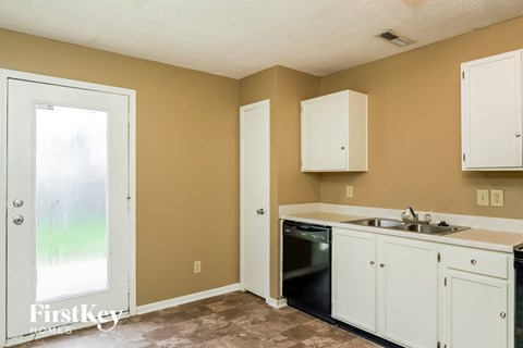 A kitchen with a black oven and white cabinets.