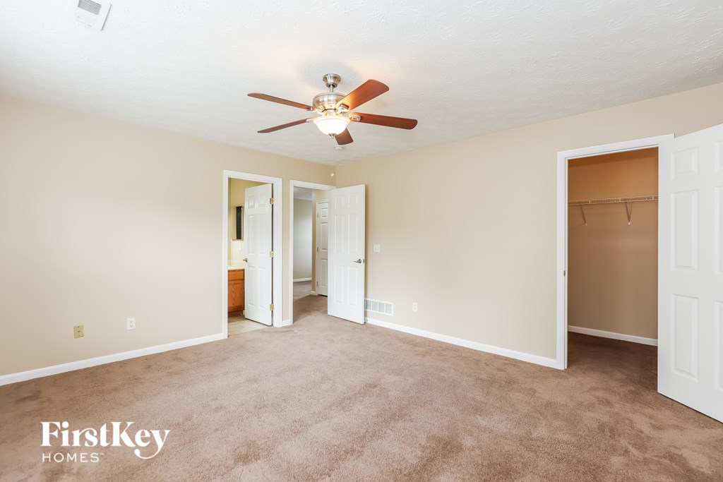 A room with a ceiling fan and a carpeted floor.