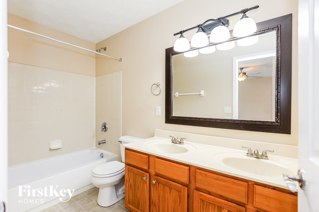 A bathroom with a white toilet, a sink, and a mirror.