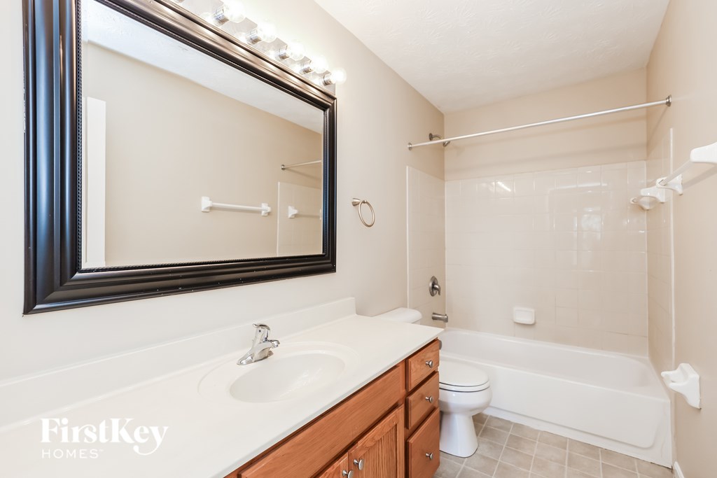 A bathroom with a white sink and a white toilet.