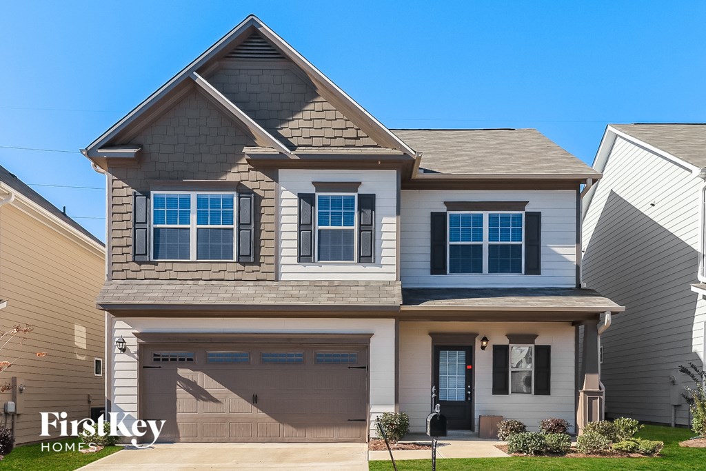 A two-story house with a garage is for sale.