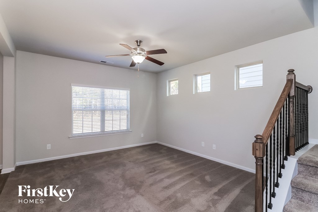 A spacious room with a staircase leading to the second floor.