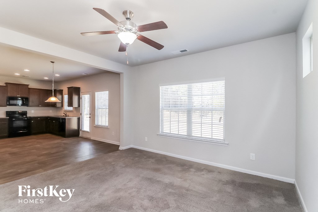 A spacious living room with a ceiling fan and a television.