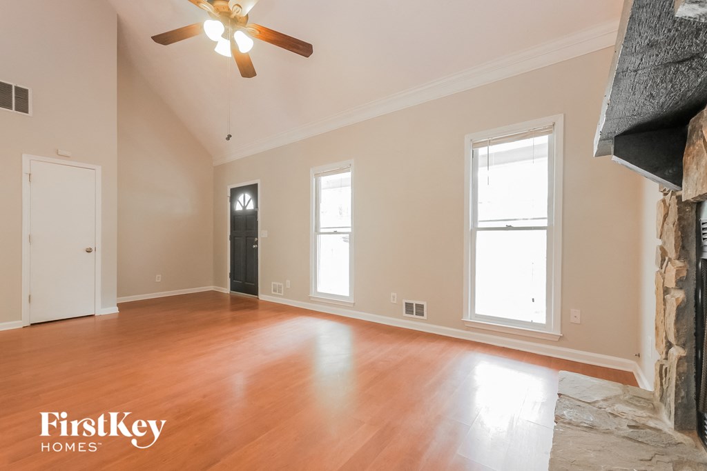 an empty living room with wood floors and a fireplace