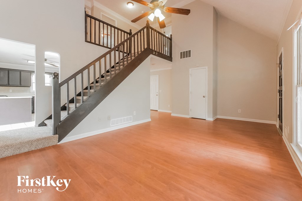 the living room and dining room with the staircase to the second floor