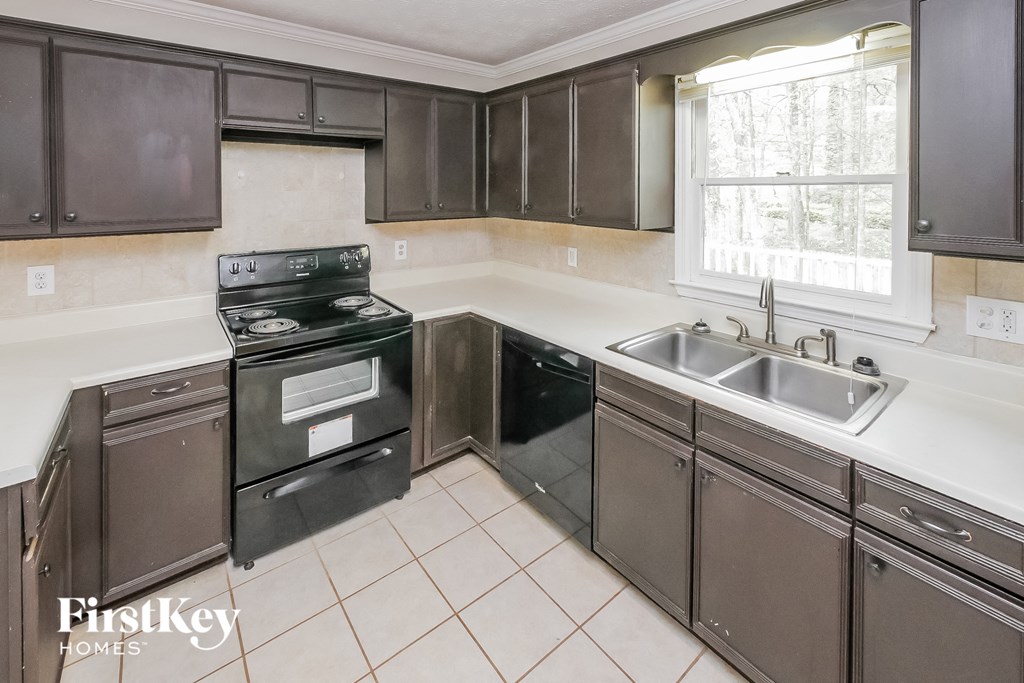 a kitchen with black appliances and white counter tops and brown cabinets