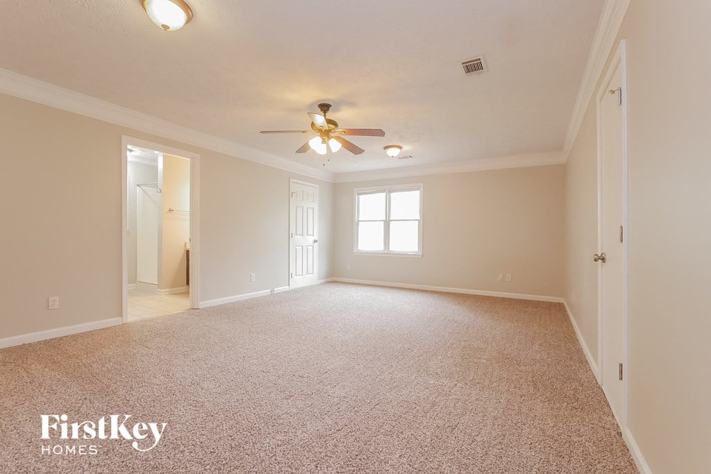 the living room of an empty house with a ceiling fan