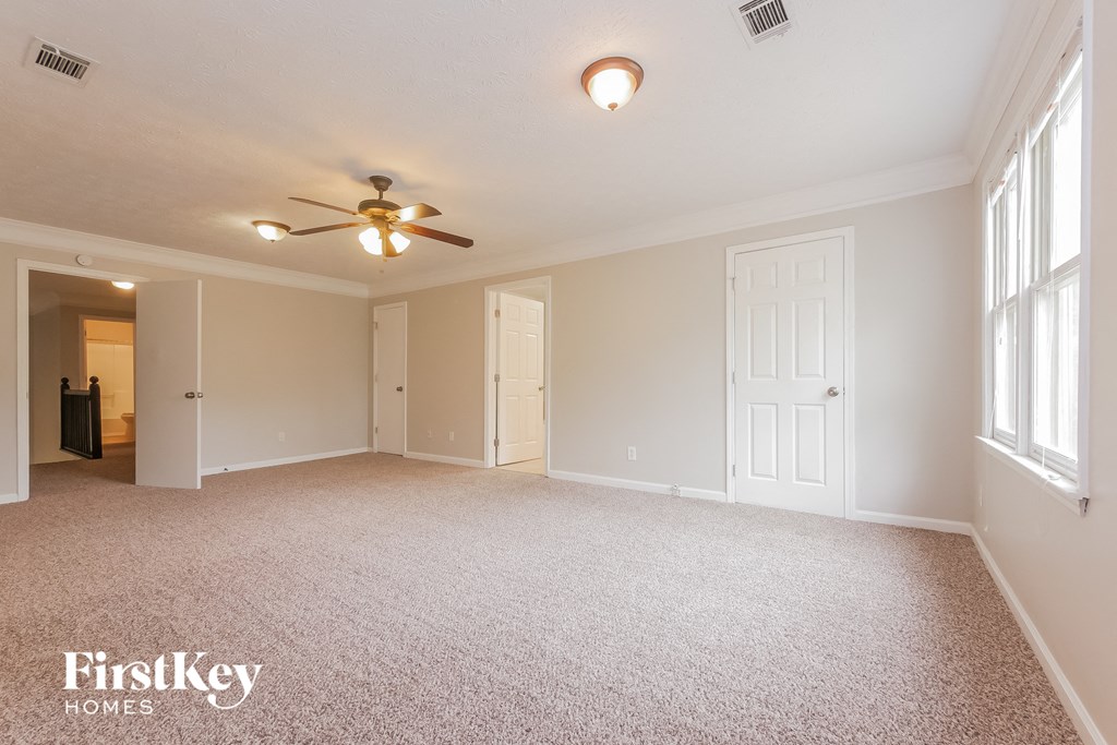 the living room of an empty house with a ceiling fan