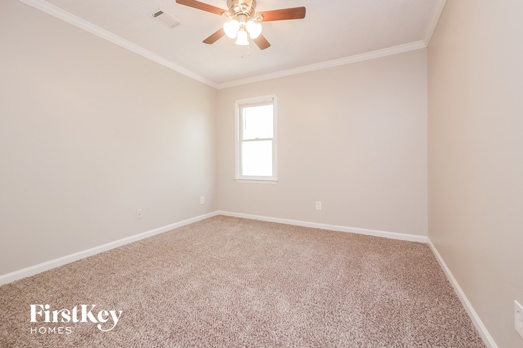 a empty room with a ceiling fan and a window