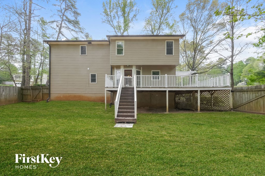 the back of a house with a deck and a yard