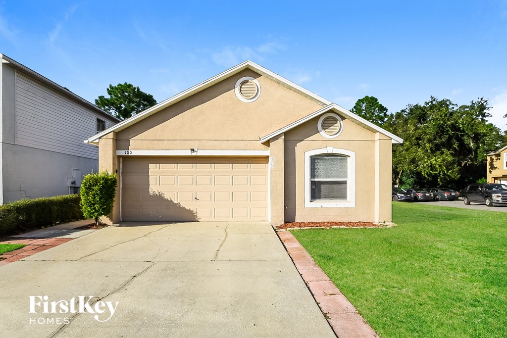 A beige house with a garage door and a window.