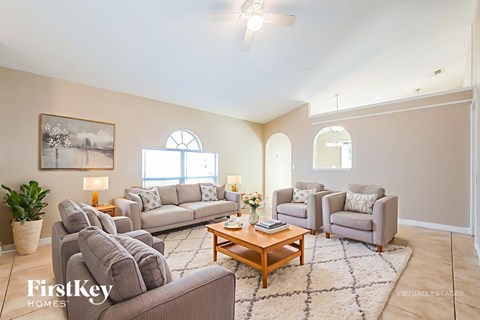 A living room with a large couch, a coffee table, and a painting on the wall.