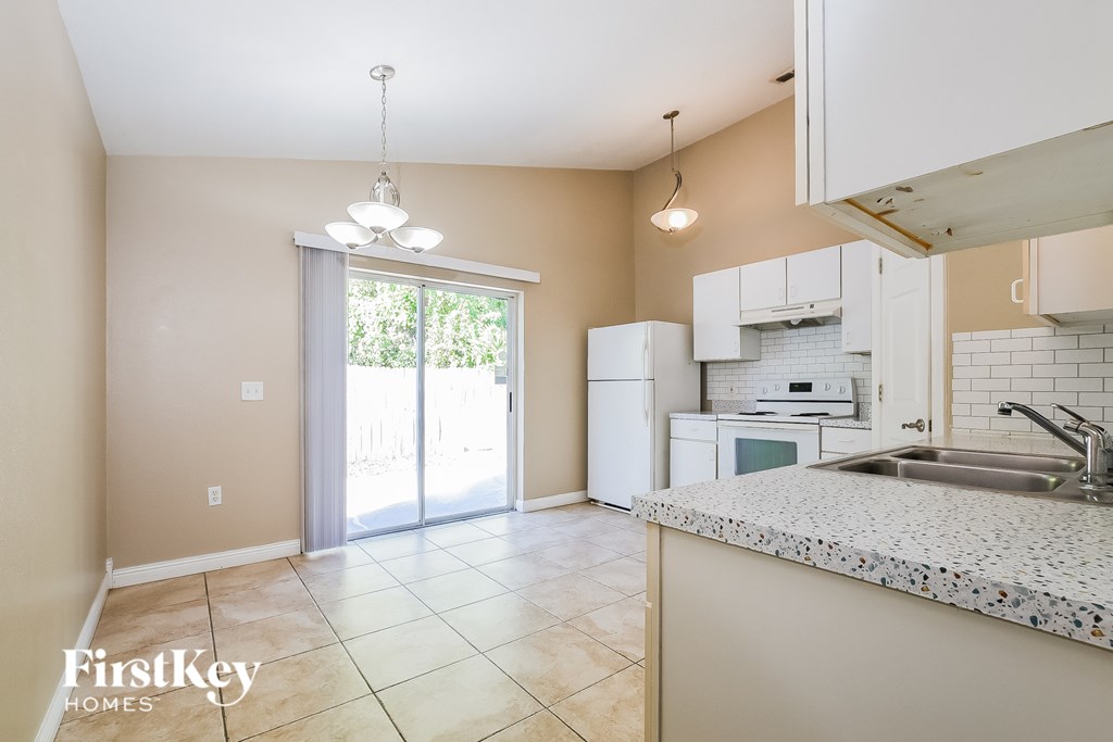 A kitchen with a white fridge and a sink.